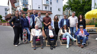 Verweilen statt durcheilen: Vertreter des Gemeinderats, der Stadtverwaltung und der begleitenden Firma USP mit Dr. Sonja Rube (l.) demonstrieren, was man in der Fußgängerzone Karlsruher Straße unternehmen kann.