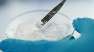 Eine Vulcan-Mitarbeiterin hält in einem Labor eine Glasschale mit Lithiumchlorid in den Händen. Das soll bald durch die Bohrungen der Geothermie gewonnen werden.