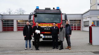 Bürgermeister Matthias Beck (2. v. l.) präsentiert mit dem Leiter der städtischen IT Christian Schleyer (v.l.), dem hauptamtlichen Feuerwehrkommandant Daniel Ernst, Klaudia Radecka und Mathias Scherpe von der MVV Energie AG die Kamera für die zukünftige Überwachung der Feuerwehrzufahrt.