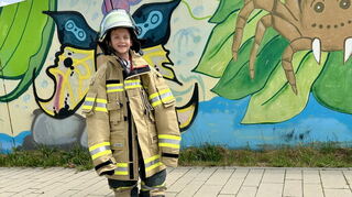 Vielleicht das nächste Mitglied für die Jugendfeuerwehr? Schüler Ben in Feuerwehrausrüstung.