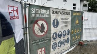 Auf großen Transparenten wird darauf hingewiesen, dass der Baustellenbereich nur von Befugten in entsprechendem Vollschutz betreten werden darf.