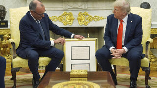 Bundeskanzler Friedrich Merz (CDU) überreicht US-Präsident Donald Trump die Geburtsurkunde seines Großvaters väterlicherseits im Oval Office des Weißen Hauses.