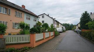 Eine typische Szenerie im südlichen Teil der Siedlung: Die Doppelhäuser sind architektonisch schlicht gehalten, verfügen aber über große Gärten. Früher dienten sie dem Anbau von Obst und Gemüse oder der Tierhaltung, heute sind sie oft grüne Refugien für die Erholung der Bewohner.