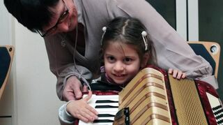 Jugendmusikschulleiter Birgit Drath erklärt einer jungen Schülerin, wie das Akkoredon die Töne erzeugt, die man hören will.