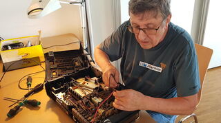 Helfer Joachim repariert ein altes Radio.