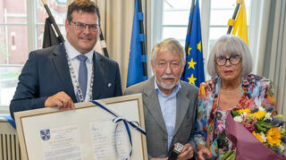 Bürgermeister Nils Drescher überreicht den Ehrenbürgerbrief an den Geehrten Professor Dr. Dr. Ulrich Mende, der von seiner Ehefrau Brigitte Mende begleitet wurde.