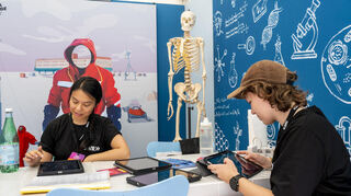 Fest und Pauline probieren den Stand Planet Schule aus.