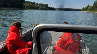 Es dauerte, bis die Brühler Feuerwehr beim Rheinalarm am Mittwoch ihre Position beziehen konnte. Im Hintergrund die Rauchsäule des Großbrandes in Mannheim.