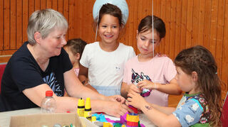 Birgit Schmitt (Musikfreunde Reilingen) bastelt mit Malia (5), Valeria (5) und Noemi (6).