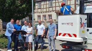 Bürgermeister Stefan Weisbrod (v. l.), Benedict Schneider (MVV), Peter Kneis, Bauamtsleiterin Ramona Drexler, Patrick Herrmann (MVV) und stellvertretender Bauamtsleiter Tobias Hardtmann freuen sich über den Start des Projekts, bei dem die Straßenlaternen mit solchen LED-Leuchten ausgestattet werden.
