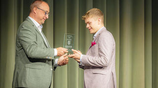 Der Vorsitzende des Elternbeirats Uli Philipp überreicht den Gauß-Preis an Jonas Röser.