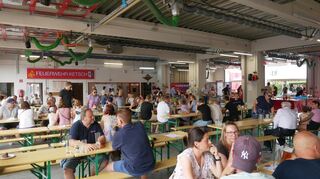 In der Fahrzeughalle können die Besucher an zahlreichen Bierbänken Platz nehmen und das breite Angebot an Speisen und Getränken stilecht genießen.