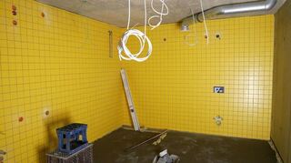 Die Fliesenleger gestalten derzeit die Dusch- und Sanitärräume mit hellen Farben, die ein wenig an die alte Mehrzweckhalle erinnern.