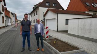 Noch fehlen Bäume und Grünpflanzen, aber die Häuser sind wieder anfahrbar und die Technik im Boden ist samt Kanal rundum erneuert: Ortsbaumeister Nico Rößler (l.) und Bürgermeister Timo Wangler im fertigen Teilstück der Enderlestraße.