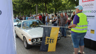 Oldtimer-Parade durch das aufblasbare ADAC-Zieltor am Schwetzinger Schlossplatz.