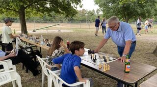 Am Brett sitzend (v. l): Lea Laukemann und Matteo Camilleri fordern Simultanspieler Manfred Werk heraus.