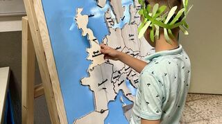 Ein Junge versucht sich am Europa-Puzzle.