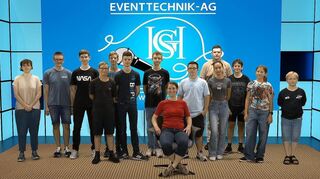 Die Technik-AG vor einem virtuellen Hintergrund: Lina Thiemann (v.l.), Felix Eisendick, Maksim Sklyarenko, Tammo Pfeiffer, Benjamin Schlüssler, Marcel Kaufka, Leon Schäfer, AG-Leiterin Carmen Boettcher, Torben Trapp, Colin Eberle, Heidi Stöckner, Timon Völker, Enrik Rehberger und Maximilian Süssenbach.