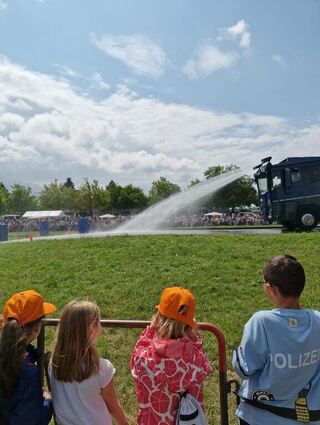 Der Wasserwerfer beeindruckt die Kinder aus Plankstadt sehr. Aus sicherer Entfernung dürfen sie das Fahrzeug im Einsatz beobachten.