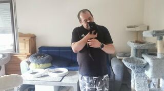 Tierpflegehelfer Chris mit einer der Katzen.