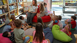 Petra Marx liest den Kindern die Geschichte von der Kuh „Rosalinde“ vor.