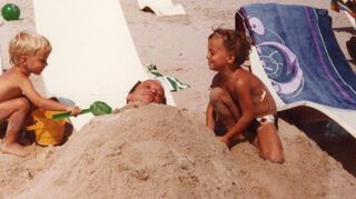 Pascal (l.) und Marcel buddeln Mitte der 80er Jahre am Strand ihren Papa ein.