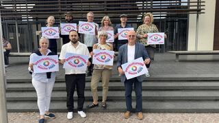 Die Akteure halten das offizielle Logo der Interkulturellen Woche 2025, die auch in Schwetzingen stattfindet, hoch: Maria Thöle (hintere Reihe v. l.), Usama Saleem Janjua, Karlheinz Seitz, Pia Dörr, Hermann Ungerer Henríquez, Ulrike Keßler, Gabriele Wurl (vordere Reihe v. l.), Ali Altiparmak, Margit Rothe, Manfred Kern.