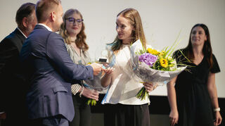 Amélie Sophie Chloe Kalt schnitt als Prüfungsbeste im Bereich Kauffrau für Hotelmanagement ab und erhält dafür von Tobias Naht einen Pokal.