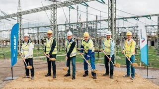 Vertreter von BASF und Amprion beim symbolischen Spatenstich zur neuen Umspannanlage für das Ludwigshafener BASF-Werk. Die alte Anlage im Hintergrund wird zurückgebaut.