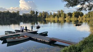 In zwei Ruderbooten wird der Angleradel über das Vereinsgewässer zum Festgelände bei der Fischerhütte des Angelsportvereins Rohrhof gebracht.