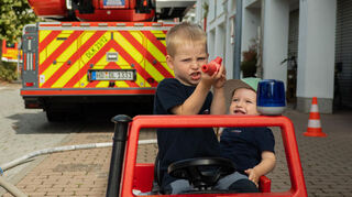 Jakob (links) und Oskar fahren mit dem Unimog in Miniaturformat über den Hof.