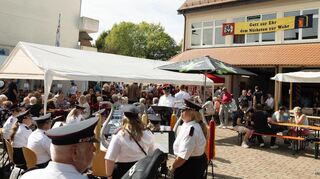 Der Spielmannszug der Feuerwehr Eppelheim spielt beim Herbstfest. Viele Besucher hören gespannt zu.