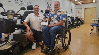 Steffen Ramer (l.) vom Brühler Sanitätshaus hat den Druck des vom Behindertenbeauftragten Rudi Bamberger erstellten Flyers „Barrierefrei Reisen“ mit einer Spende ermöglicht.