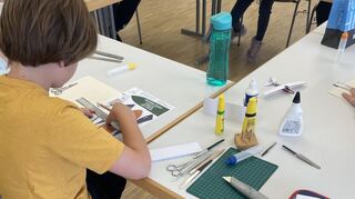 Brühler Kinder wagen mit den Kursleitern vom Zusammenschluss des Mannheimer Kreises der Kartonmodellbauer beim Ferienprogramm Sprung in dritte Dimension.