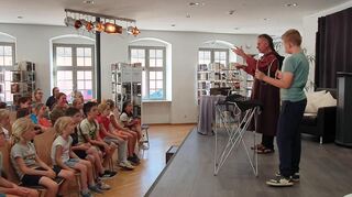 Bei der Abschlussveranstaltung von "Heiss auf Lesen" beeindruckt Lesemagier Chris Hyde das junge Publikum in Schwetzingens Stadtbibliothek.