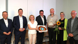 Bei der Verabschiedung in Reilingen gibt es den berühmten Käsekuchen mit besonderem Motiv. Die Präsente werden Christian Palmer und seiner Anke (3. und 2. v. r.) von Thomas Jakob-Lichtenberg (v.l.), Hockenheims Bürgermeister Matthias Beck, Ingeborg Bamberg, Reilingens Bürgermeister Stefan Weisbrod sowie Friedbert Blaschke überreicht.