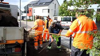 Die Männer vom Bauhof bringen Erde auf die Fläche.