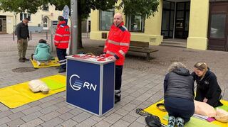 Lisa-Louise Funk (v.l.) und Vivian Bannwolf (FAFA) sowie Dr. Julian Sänger und Philipp Klauer (Anästhesie GRN-Klinik Schwetzingen) zeigen am Aktionsstand auf den Kleinen Planken, wie eine Herzdruckmassage funktioniert.