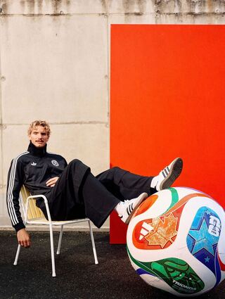 Woltemade posiert lässig mit dem übergroßen Modell des WM-Balls.