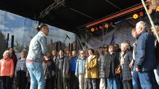 Chorleiter Matthias Tropf mit den Sängerinnen und Sängern der Chorgemeinschaft Brühl sorgen während der Kerwe für gute Stimmung bei herbstlichem Wetter.