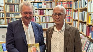 Jean Asselborn (l.) präsentiert die im September über ihn erschienene Biografie "Die Tour seines Lebens" in der Buchhandlung von Christoph Kieser.