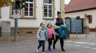 Greta (6), Ida (7) und Michelle Balduf überqueren die Straße an der Ampel beim evangelischen Kindergarten Regenbogen in der Rheinhäuser Straße.
