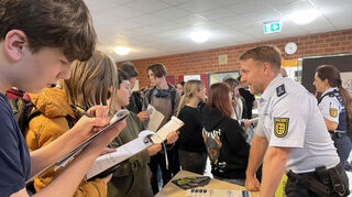 Fleißig füllen die Schülerinnen und Schüler den Fragebogen des „Berufe-Parcours“ am Stand des Polizeipräsidiums Mannheim aus.