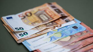 Zahlreiche Euro-Banknoten liegen auf einem Tisch.