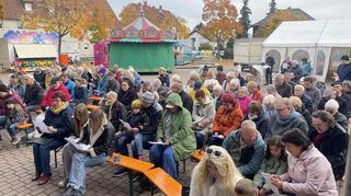 Die Besucher nehmen am Gottesdienst auf dem Festplatz teil.