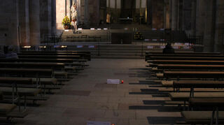 Kerzen leuchten auf den Grabplatten für die Bischöfe im Dom zu Speyer.