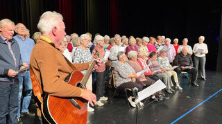 Der große Chor des kommunalen Seniorentreffs singt mit Inbrunst und Gitarrenbegleitung von Rolf Schuhmacher (l.).