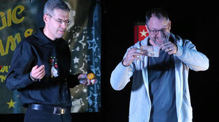 Gast Stefan Junker (r.) freut sich über seinen Geldschein, der verbrannt zu sein schien, aber in einer Zitrone wieder auftauchte.