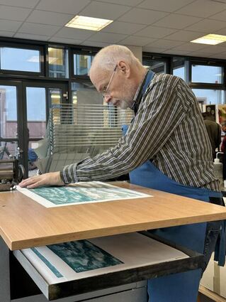 Klaus Raasch zeigt, wie er seine Druckwerke gestaltet.