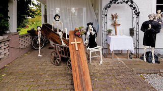 Skelette und ein Sarg sind auf dem Grundstück aufgestellt.